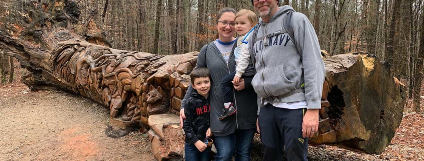 In front of the log art at Umstead Park